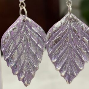 Pendientes en forma de espiga, en color malva con brillo plateado.